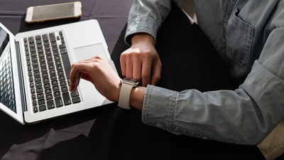 穿着蓝色牛仔夹克使用macbook pro的人
